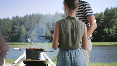 Handheld-video-of-daughter-helping-father-with-barbecue-grill