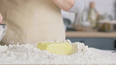 Close-up-video-of-falling-block-of-butter-into-flour