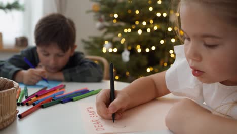 Ein-Süßes-Kleines-Mädchen-Schreibt-Mit-Ihrem-Bruder-Einen-Brief-An-Den-Weihnachtsmann