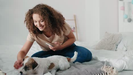 Teenage-girl-having-fun-with-her-dog-in-bedroom