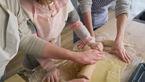 Video-of-grandma-helping-her-granddaughter-rolling-dough