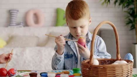 Niño-Concentrado-Pintando-Huevos-De-Pascua