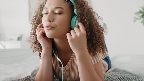 Young-woman-listening-to-music-in-her-bed