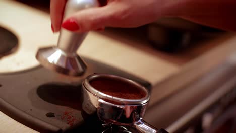 Barista's-hand-tamping-fresh-ground-coffee