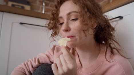 Young-caucasian-woman-eating-greedily-some-snacks.