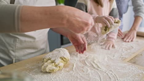 Close-up-video-of-women-sprinkling-flour-and-kneading-dough