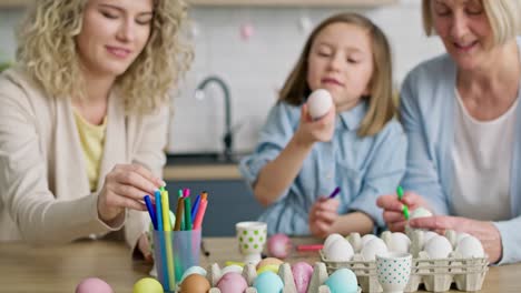 Tilt-up-video-of-girl-painting-Easter-egg-with-family