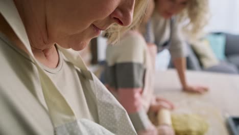 Close-up-video-of-grandma-with-family-rolling-Easter-dough