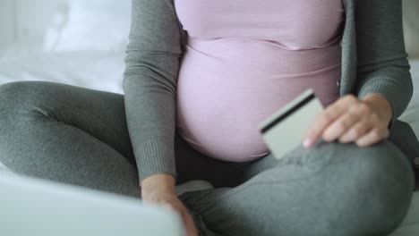 Tracking-right-video-of-unrecognizable-pregnant-woman-with-credit-card.