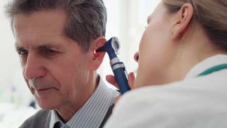 Handheld-view-of-female-doctor-examining-ear-of-senior-man