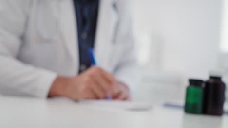 Handheld-view-of-blurred-doctor-writing-a-prescription