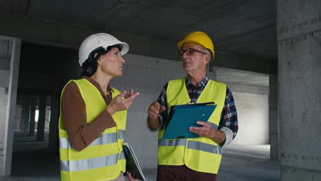 Handheld-static-video-of-male-and-female-caucasian-engineers-discussing-and-pointing-on-the-construction-site.