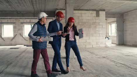 Wide-shot-video-of-group-of--caucasian-engineers-and-investors-walking-and-discussing-on-construction-site