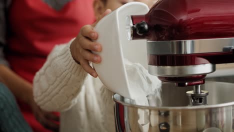Video-of-little-boy-pouring-flour-into-electric-mixer-bowl