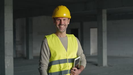 Portrait-of-caucasian-engineer-holding-digital-tablet-while-standing-on-construction-site