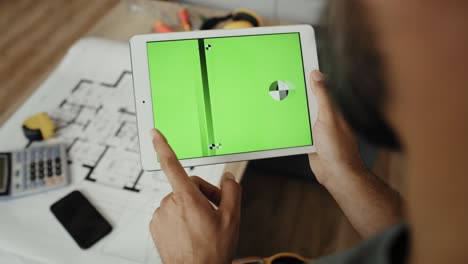 Handheld-video-of-carpenter-looking-at-something-on-a-tablet