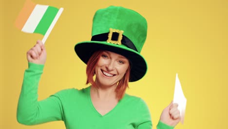 Playful-woman-with-leprechaun's-hat-and-Irish-flags-dancing