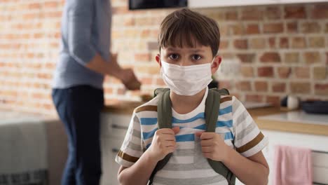 Video-portrait-of-schoolboy-in-protective-face-mask-with-backpack