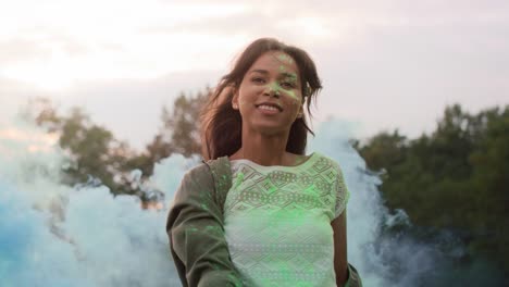 Multiracial-woman-dancing-with-coloured-smoke-bombs-at-Holi-Festival