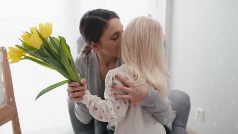 Elementary-age-girl-about-to-hand-in-flowers-to-her-mother.