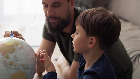 Handheld-video-of-son-and-father-looking-at-spinning-globe
