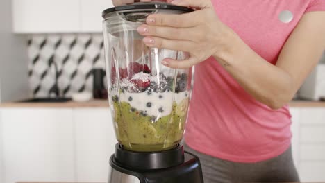 Woman-putting-the-ingredients-in-the-blender-and-mixing-them