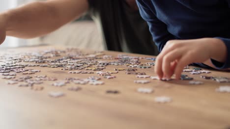 Close-up-video-of-father--solving-jigsaw-puzzle-with-son