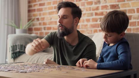 Handheld-video-of-boy-solving-jigsaw-puzzle-with-father