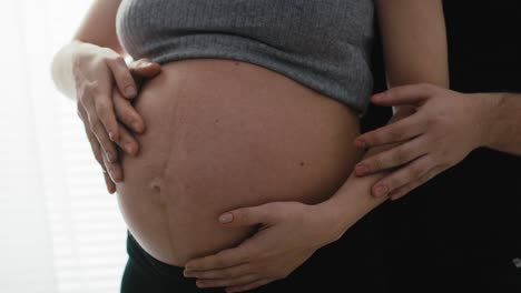 Detail-Der-Mutter-In-Fortgeschrittener-Schwangerschaft-Und-Des-Zukünftigen-Vaters,-Der-Den-Bauch-Berührt.