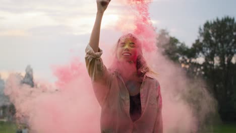Caucasian-woman-dancing-with-coloured-smoke-bombs-at-Holi-Festival