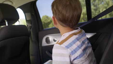 Video-Portátil-De-Un-Niño-Con-Una-Tableta-Durante-Un-Viaje-Por-Carretera