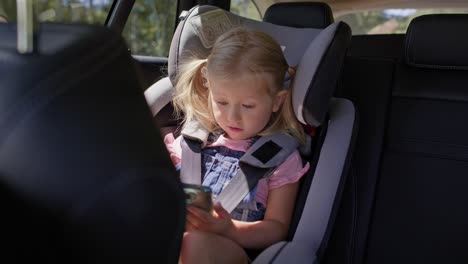 Video-Eines-Kleinen-Mädchens-Auf-Dem-Rücksitz-Eines-Autos-Mit-Telefon