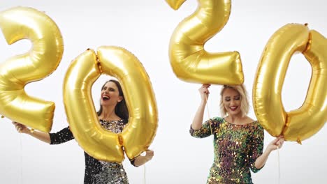 Frauen-Mit-Goldenen-Luftballons-Bauen-Die-Figur-„2020“