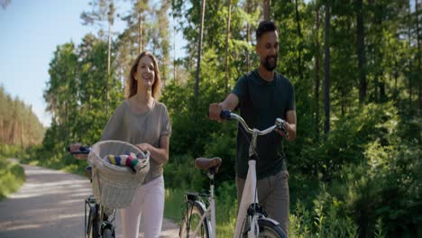 Video-of-couple-pushing-bicycle-in-the-forest