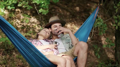 Couple-in-love-relaxing-on-hammock-in-forest