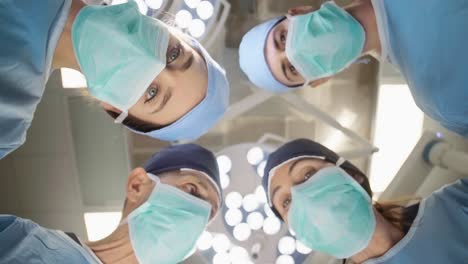 Grupo-De-Cirujanos-Conversando-Sobre-La-Mesa-De-Operaciones