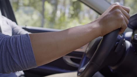 Tilt-down-video-of-handsome-man-driving-a-car.