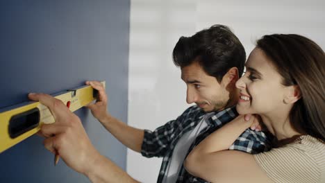 Video-of-couple-using-level-on-the-blue-wall.