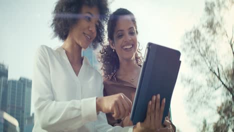 Video-of-two-businesswomen-with-digital-tablet-outdoors