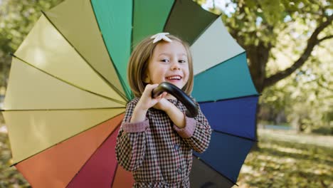 Handheld-view-of-joyful-girl-looking-for-shelter-with-umbrella