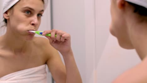 Young-woman-cleaning--teeth-in-bathroom