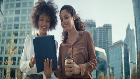 Video-of-two-businesswomen-with-digital-tablet-in-the-city