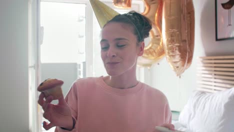 Woman-eating-birthday-cupcake-at-bedroom