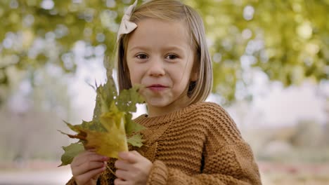 Glückliches-Mädchen-Mit-Herbstlichen-Blättern