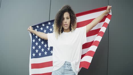 Zoom-out-video-of-young-woman-with-American-flag