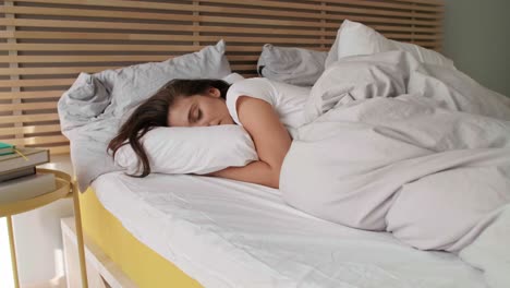 Young-woman-sleeping-in-her-bed
