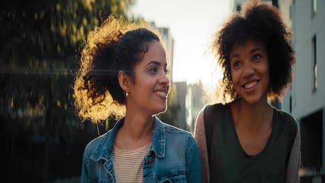 Close-up-video-of-two-smiling-female-friends-walking-together.