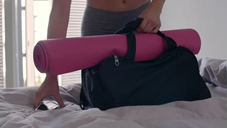 Young-woman-packing-her-gym-bag-for-all-day