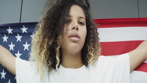 Handheld-portrait-of-young-woman-with-American-flag