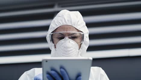 Video-of-technician-in-clean-suit-and-with-a-tablet